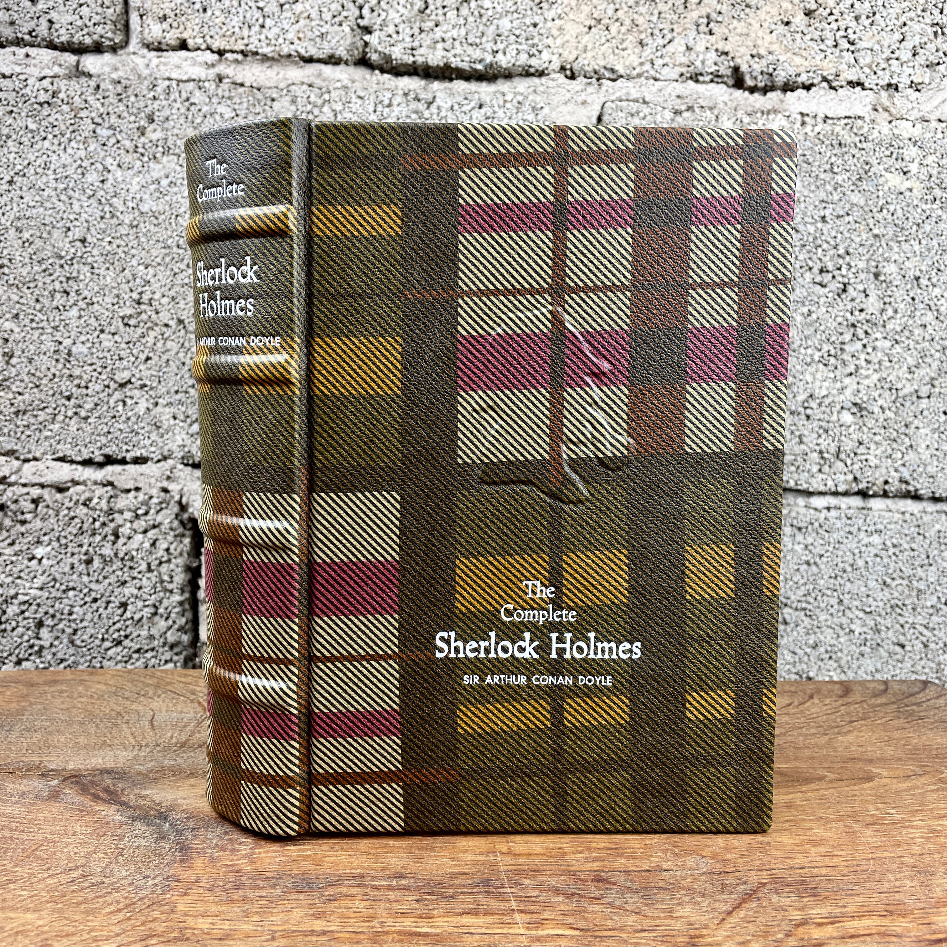 The Complete Sherlock Holmes Book: leather-bound edition with raised spine bands and plaid leather cover design.